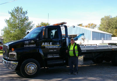 Man Posing Along with Able Towing Truck